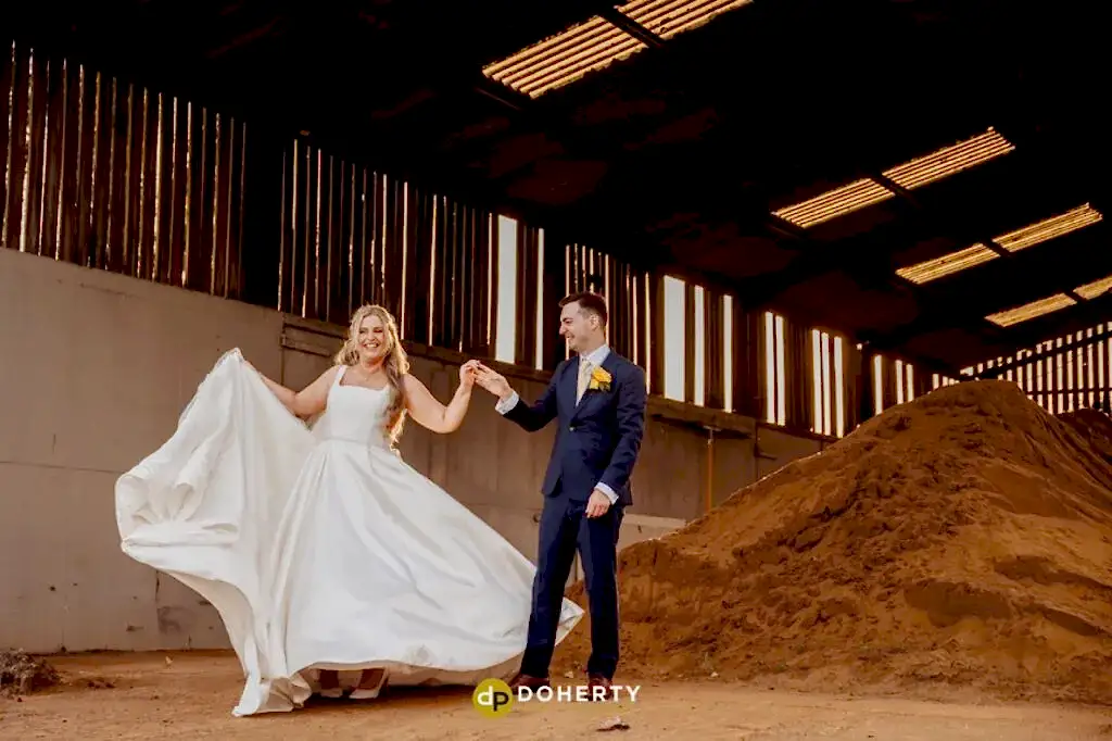 bride and groom dancing in a barn
